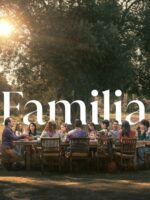 Diverse group of people seated around a long wooden table outdoors at sunset, sharing a meal, with the word 'Familia' overlaid.