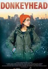 Poster for the film Donkeyhead, showing a woman in a green parka and orange beanie in a snowy cityscape background.