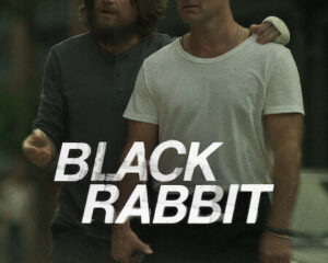 Poster for the film Black Rabbit featuring two men standing close, one with an arm around the other, with the title 'BLACK RABBIT' across the foreground.