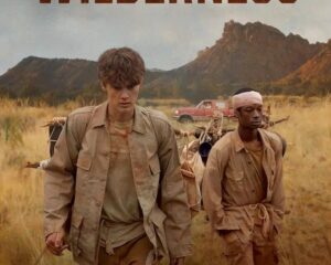 Movie poster for The Wilderness showing two men in tan clothing walking through tall grass with mountains in the distance; dusty adventure vibe.