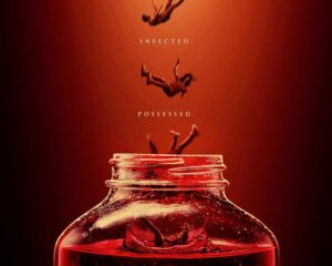 Red-tinted poster showing a large jar of red liquid with silhouettes appearing to fall into it, and the words 'Fermented', 'Infected', 'Possessed' above the jar, with 'Kombucha' at the bottom.